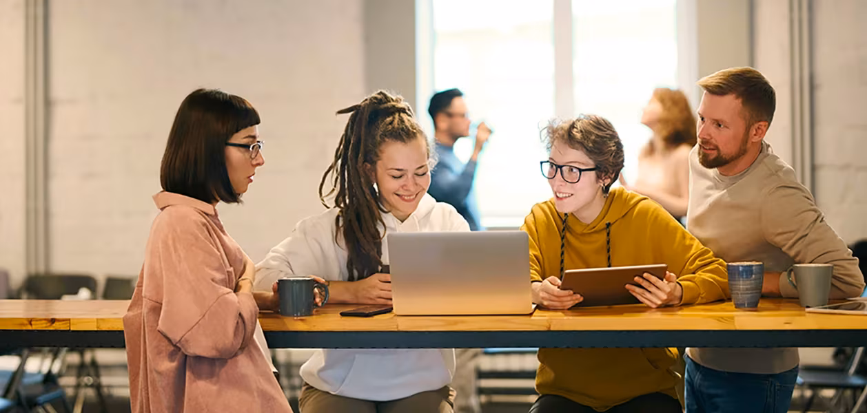 Group of people using Mac and iPad in a modern office