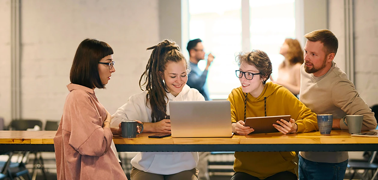 Group of people using Mac and iPad in a modern office