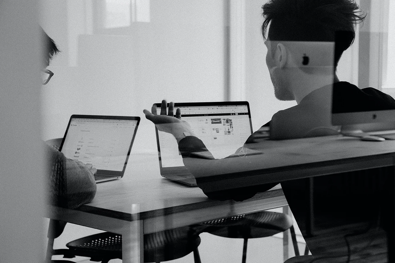 Business executives in a meeting with MacBook computers