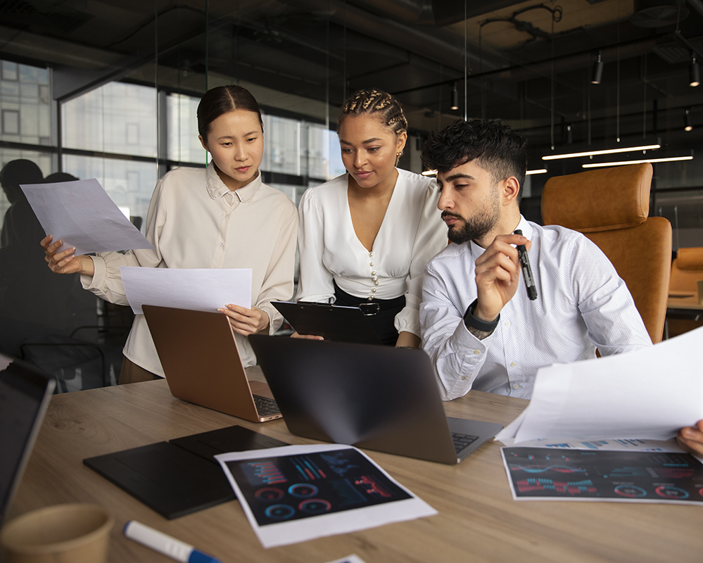 People doing some work in front of a MacBook computer