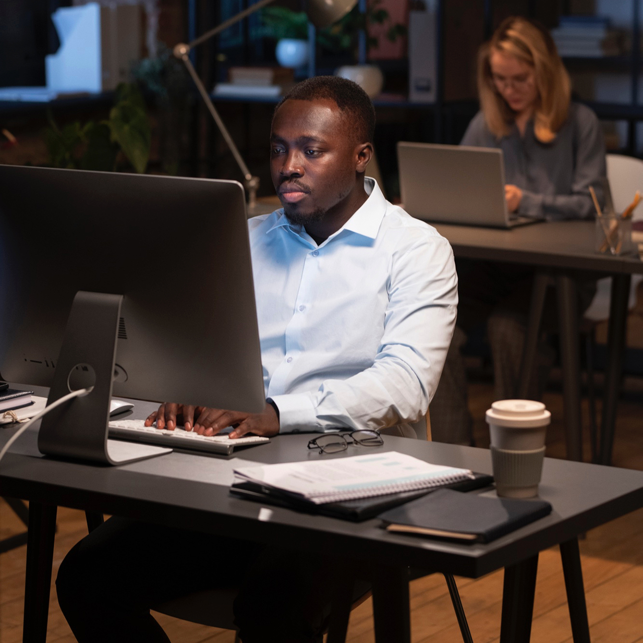 People in an office doing work on their Mac computers