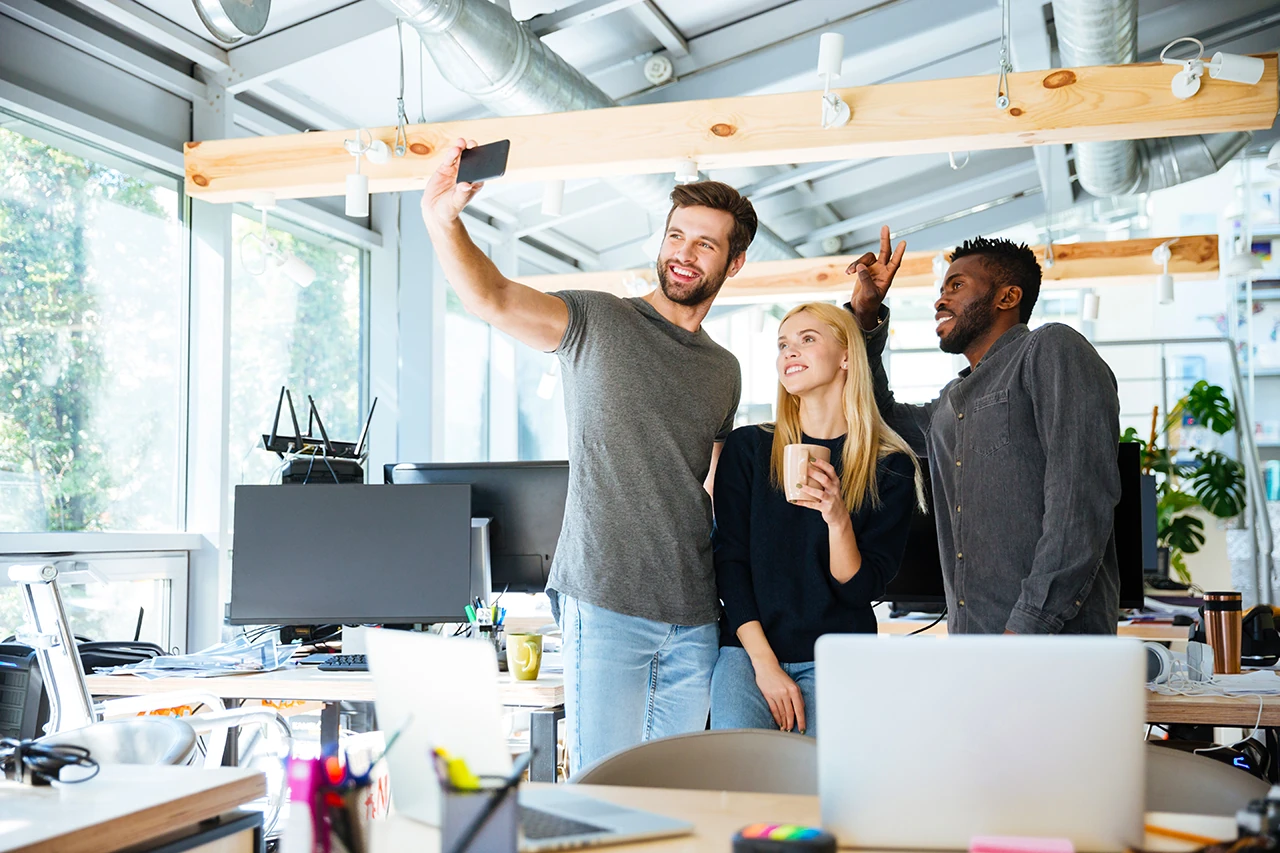 Startup workers taking a selfie with an iPhone