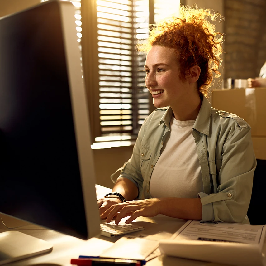 Woman staring at camera with a Mac on her lap