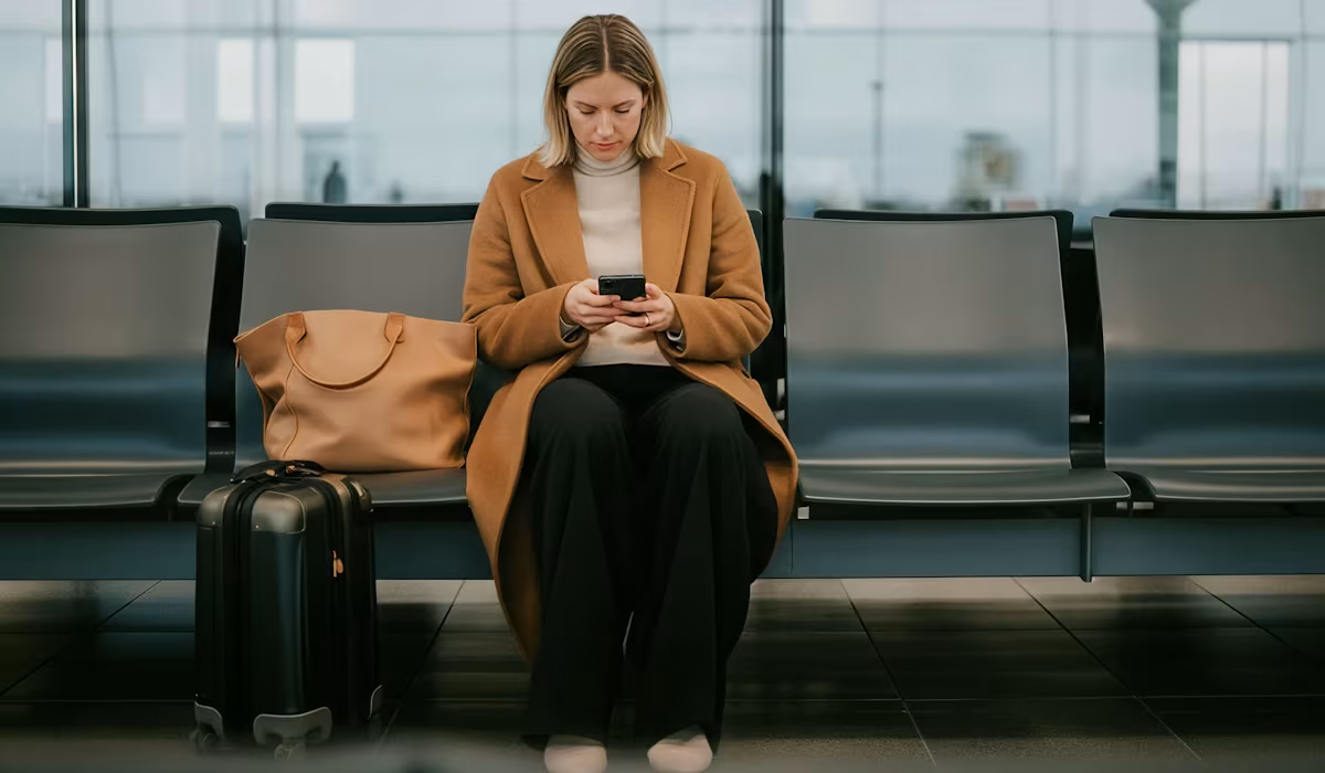 Passenger checking her iPhone while waiting for her plane