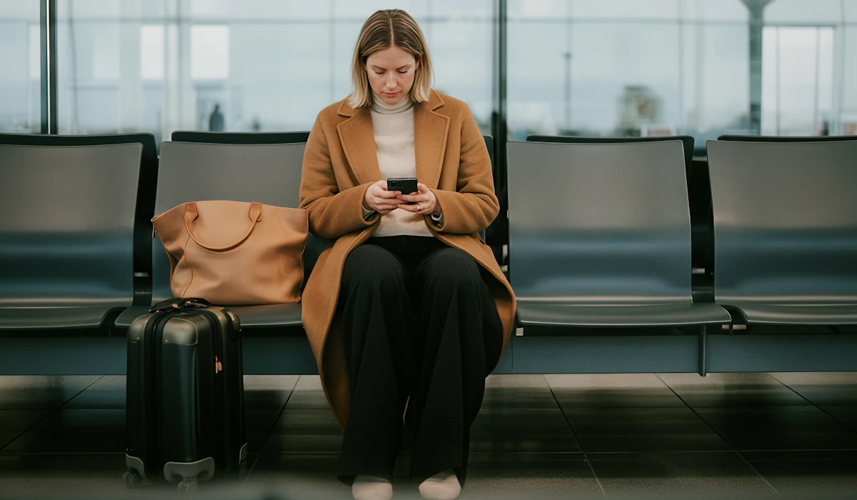 Passenger checking her iPhone while waiting for her plane